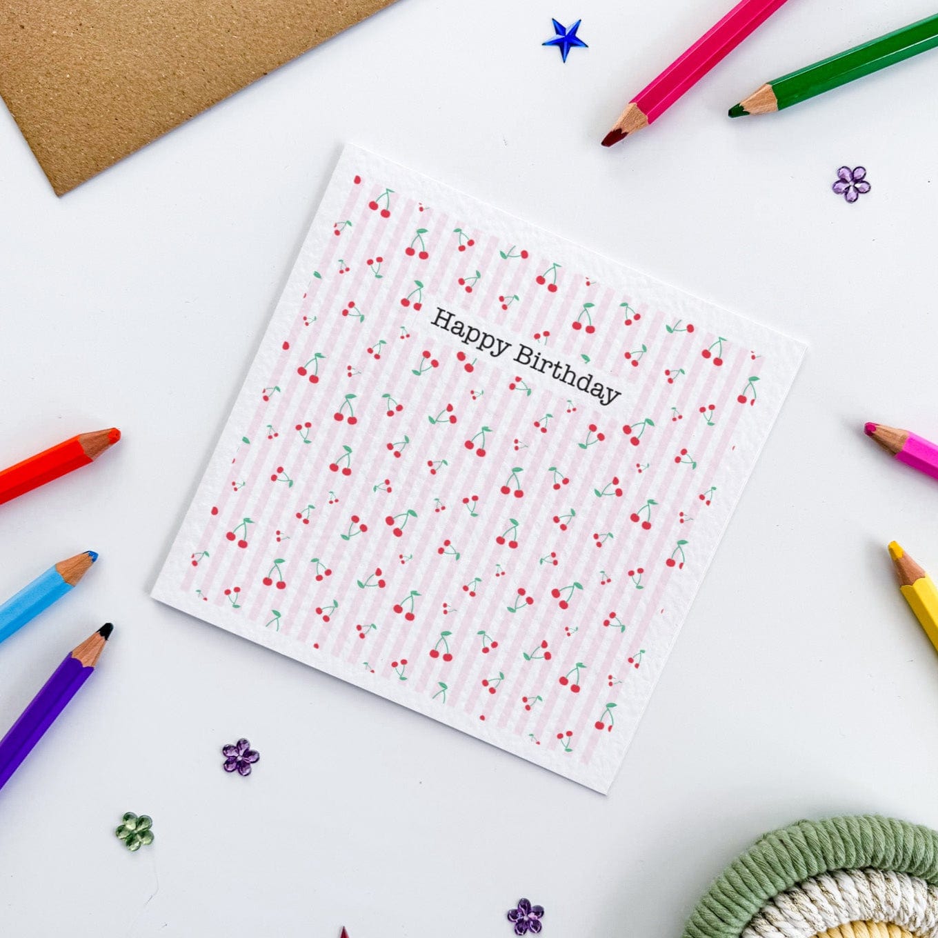 Square greetings card featuring cherry pattern and kraft envelope