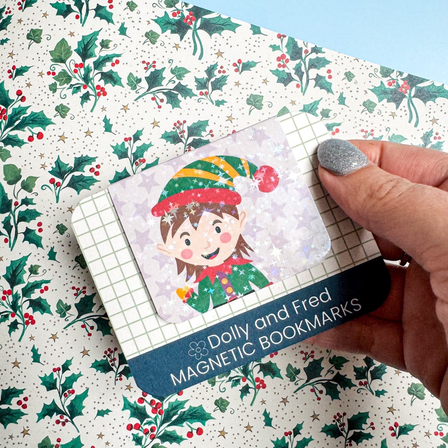 Magnetic bookmarks with an elf design on a holly leaf patterned surface