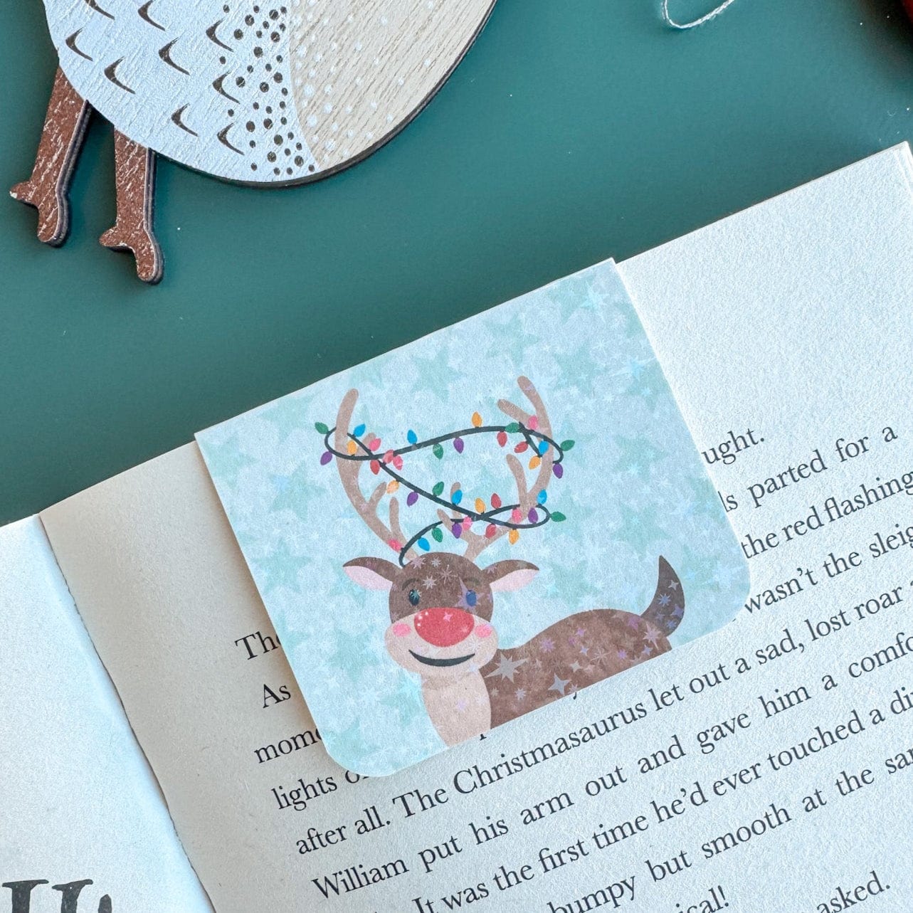 Book with a reindeer illustration and Christmas lights on a green surface