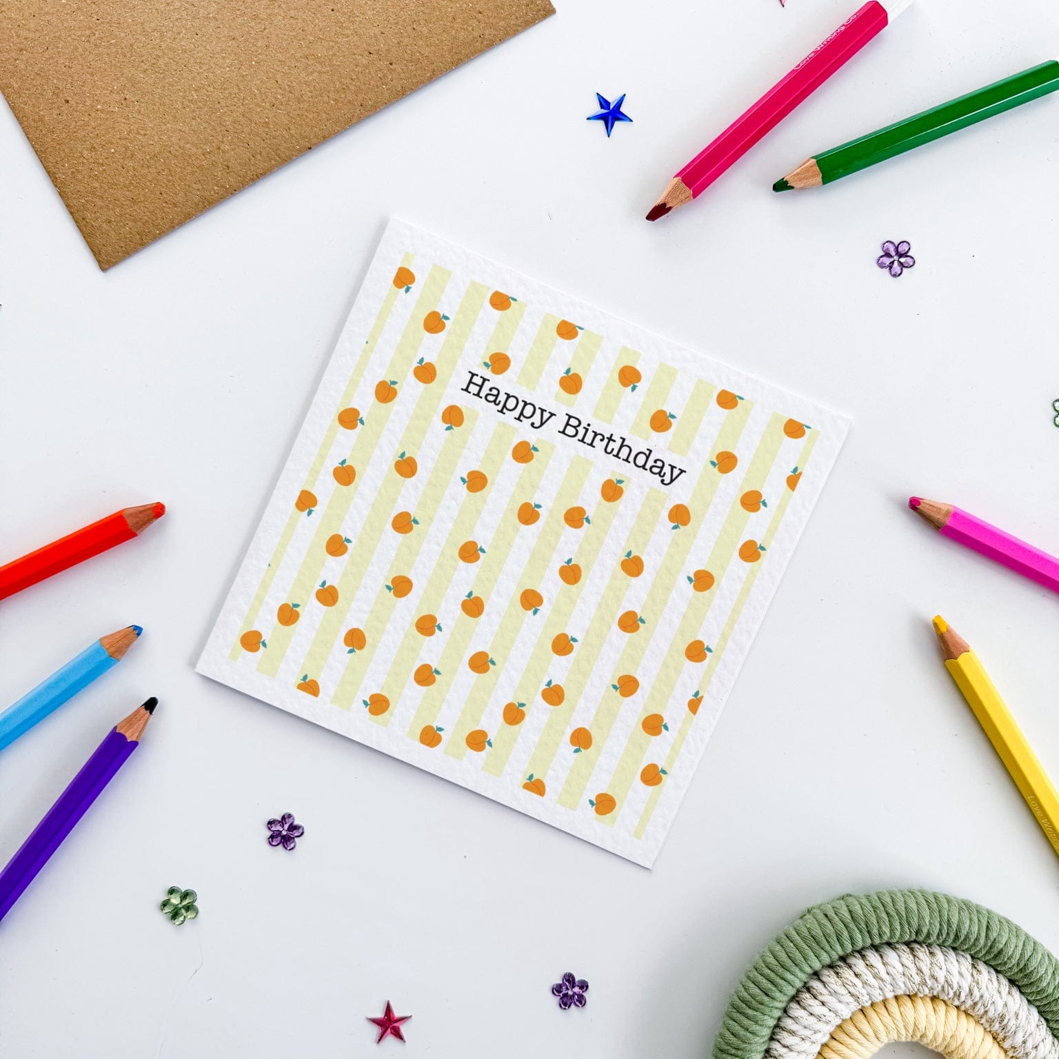 Folded greetings card with peaches, kraft envelope, and sticker sheet