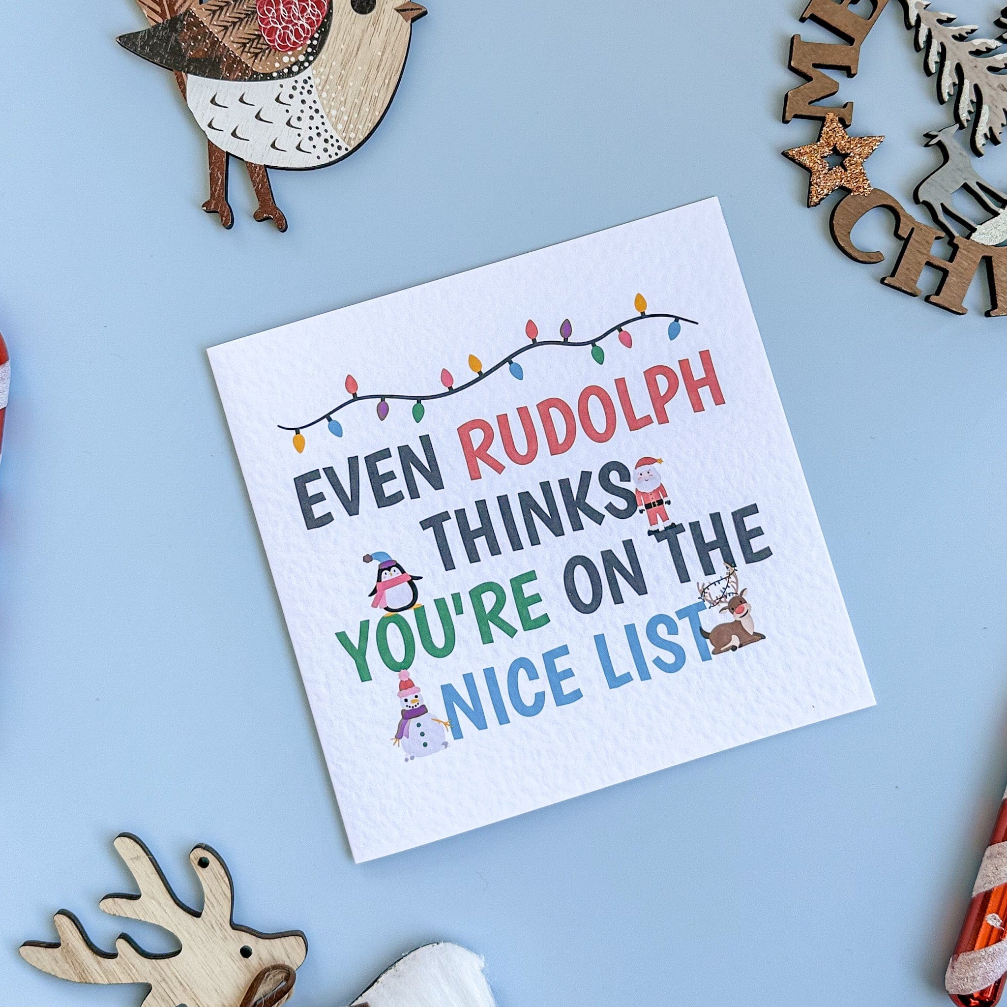 Christmas-themed card with text 'Even Rudolph thinks you're on the nice list' on a blue background with decorative elements.