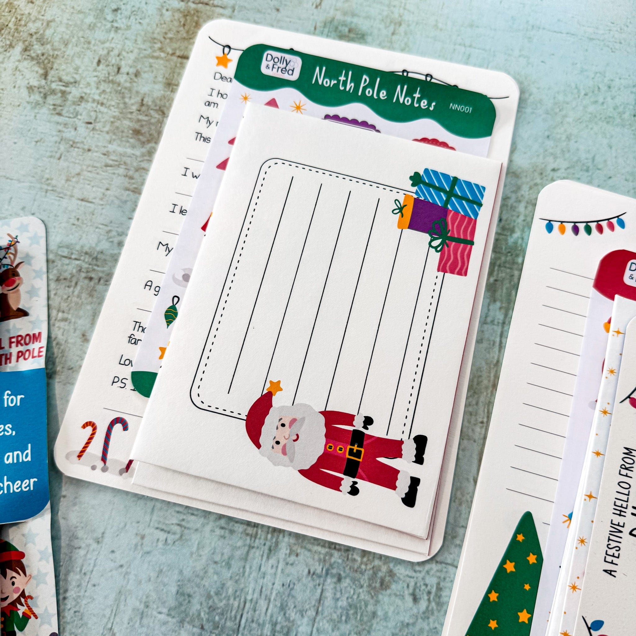 Set of Christmas-themed letters with Santa Claus design on a textured surface