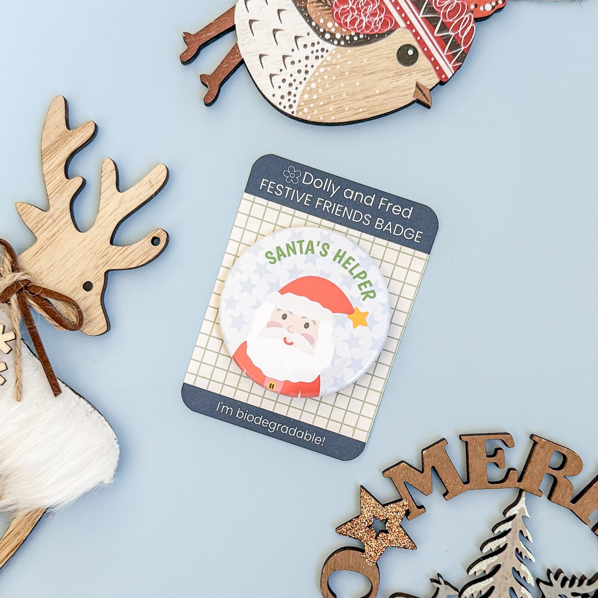 Christmas-themed badge with Santa Claus design on a blue background with decorative elements.