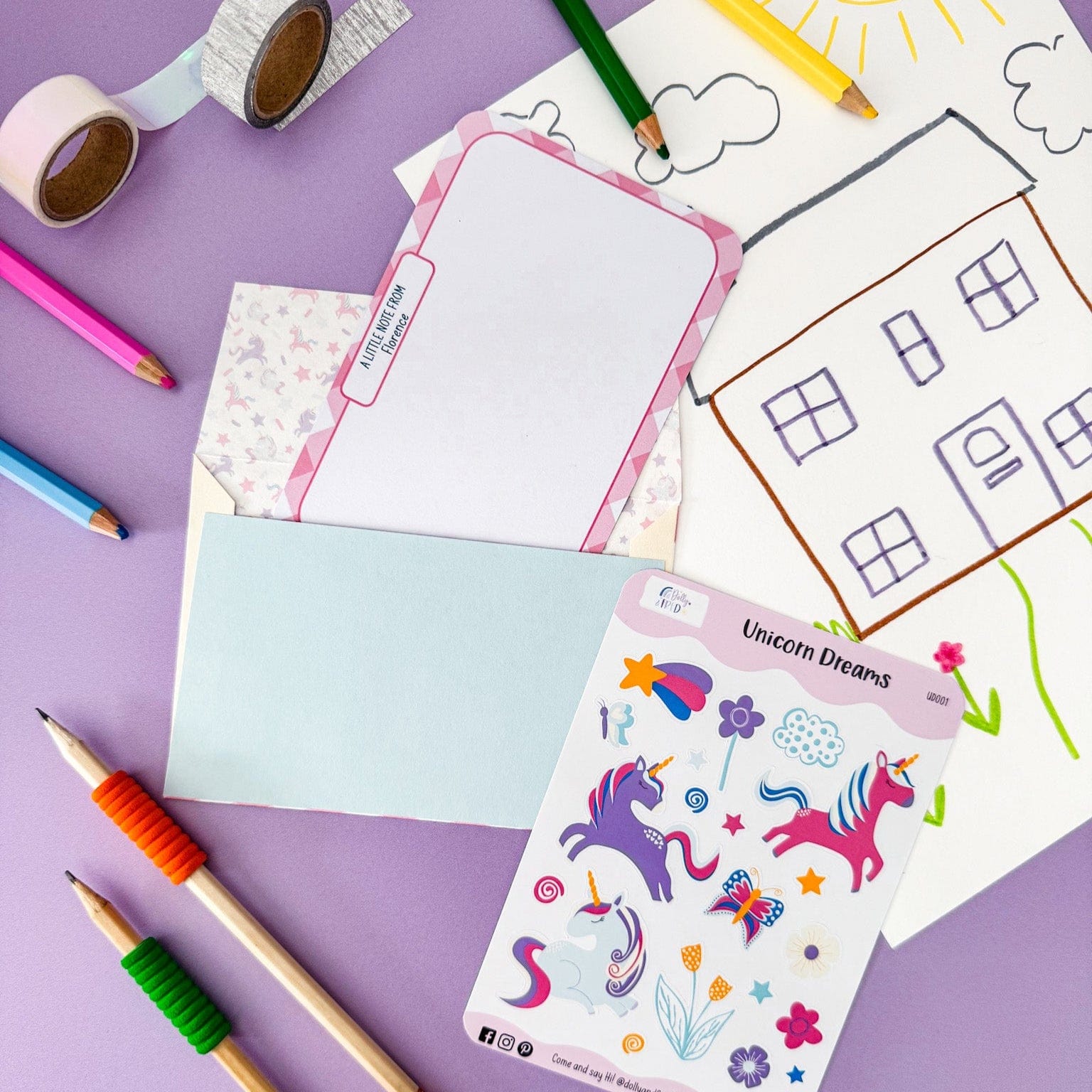 Child enjoying creative playtime with Dolly and Fred's unicorn stationery set, featuring illustrated postcards, envelopes, stickers, crayons, and drawing accessories