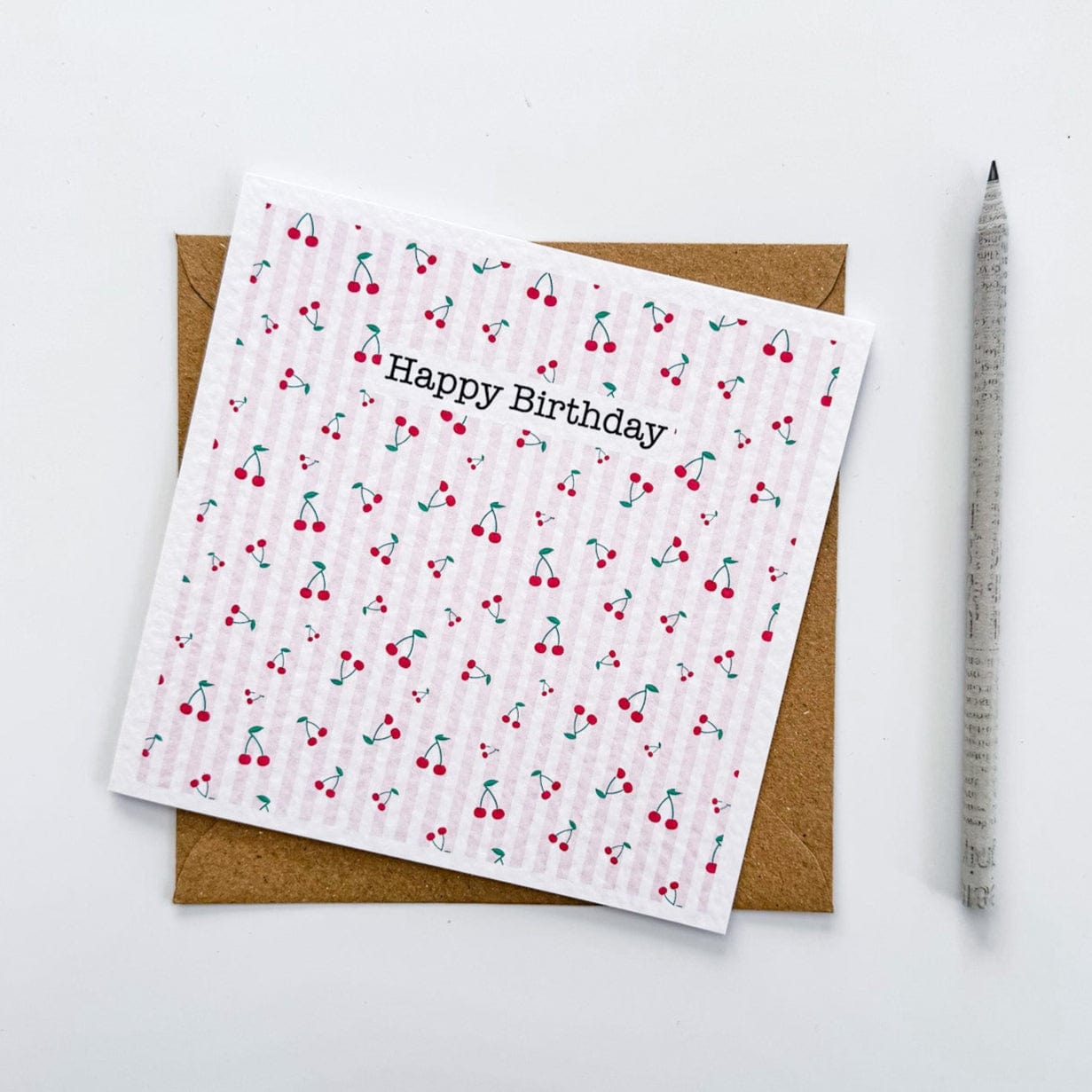 Square greetings card featuring cherry pattern and kraft envelope