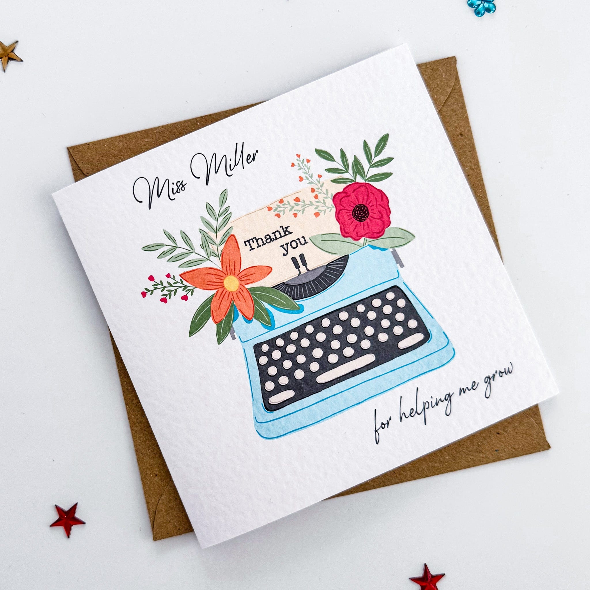 Floral teacher thank you card with handwritten name and envelope on star background.