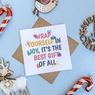 Card with motivational quote surrounded by Christmas decorations on a blue background