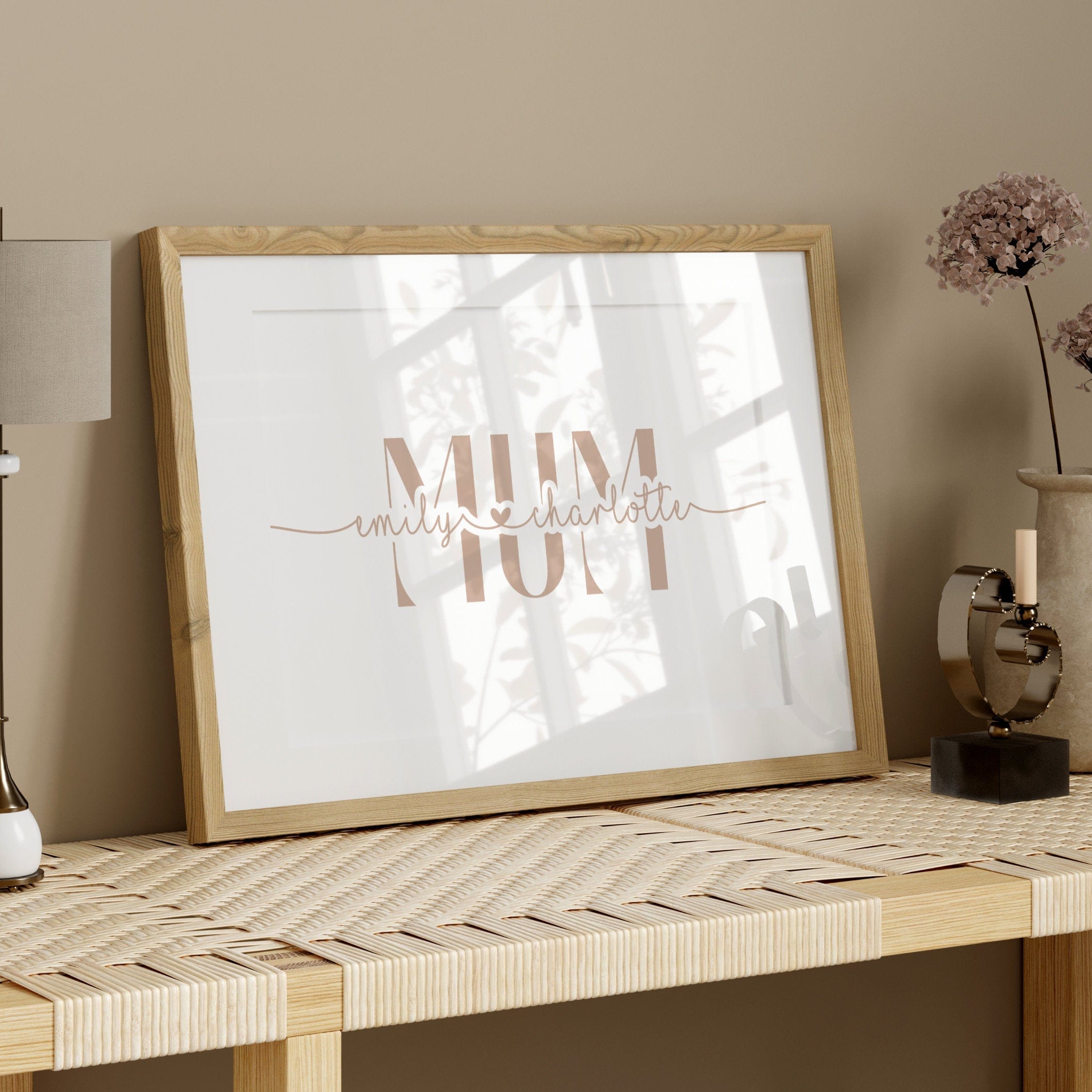 Framed artwork with 'Mum' on a table against a beige wall