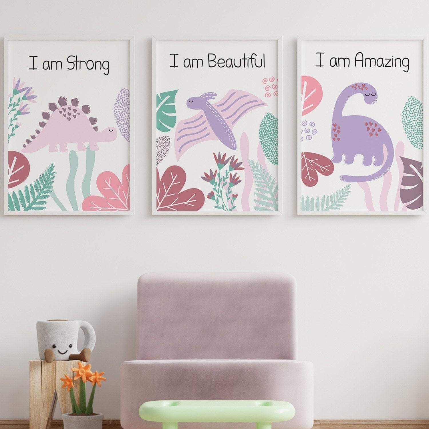Three motivational posters with dinosaur illustrations on a wall in a child's room.