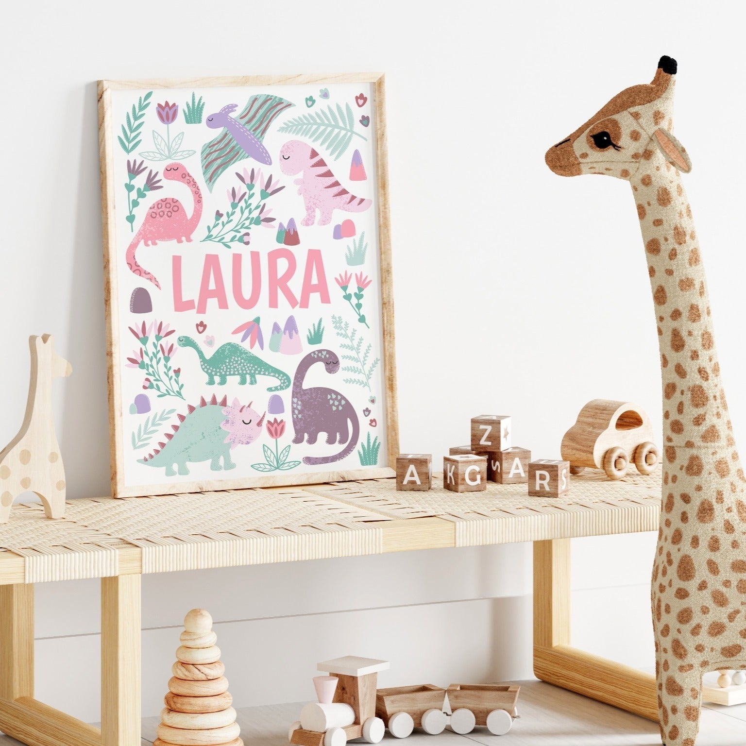 Close-up of a pink dinosaur wall art print with a personalised name option for kids' rooms.