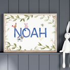 Framed artwork with 'NOAH' and farm animals on a dark gray wall with a white rabbit figurine.