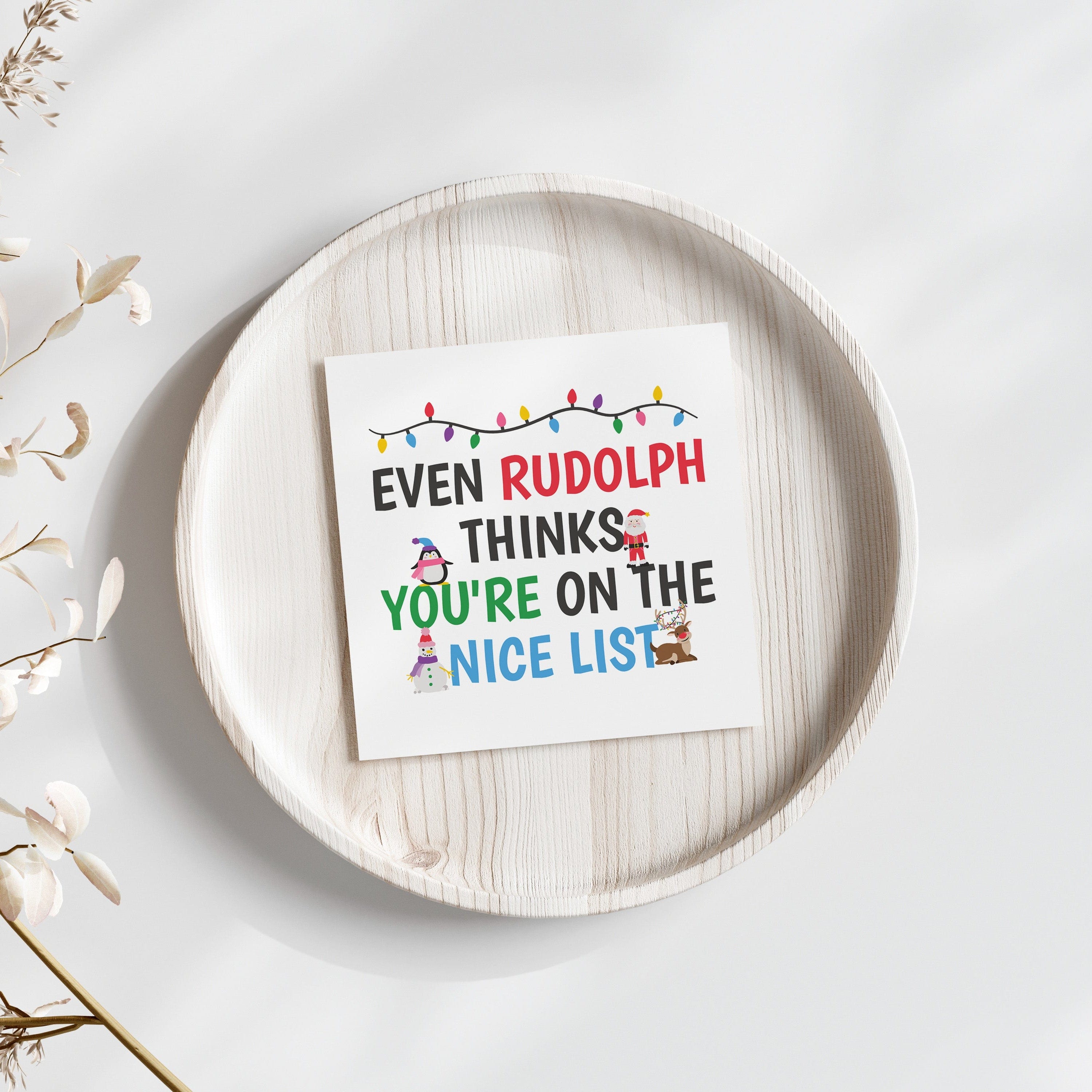 Card with Christmas message on a white plate with decorative elements.