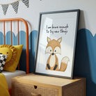 Framed picture of a fox with motivational quote on a wooden shelf in a child's room.