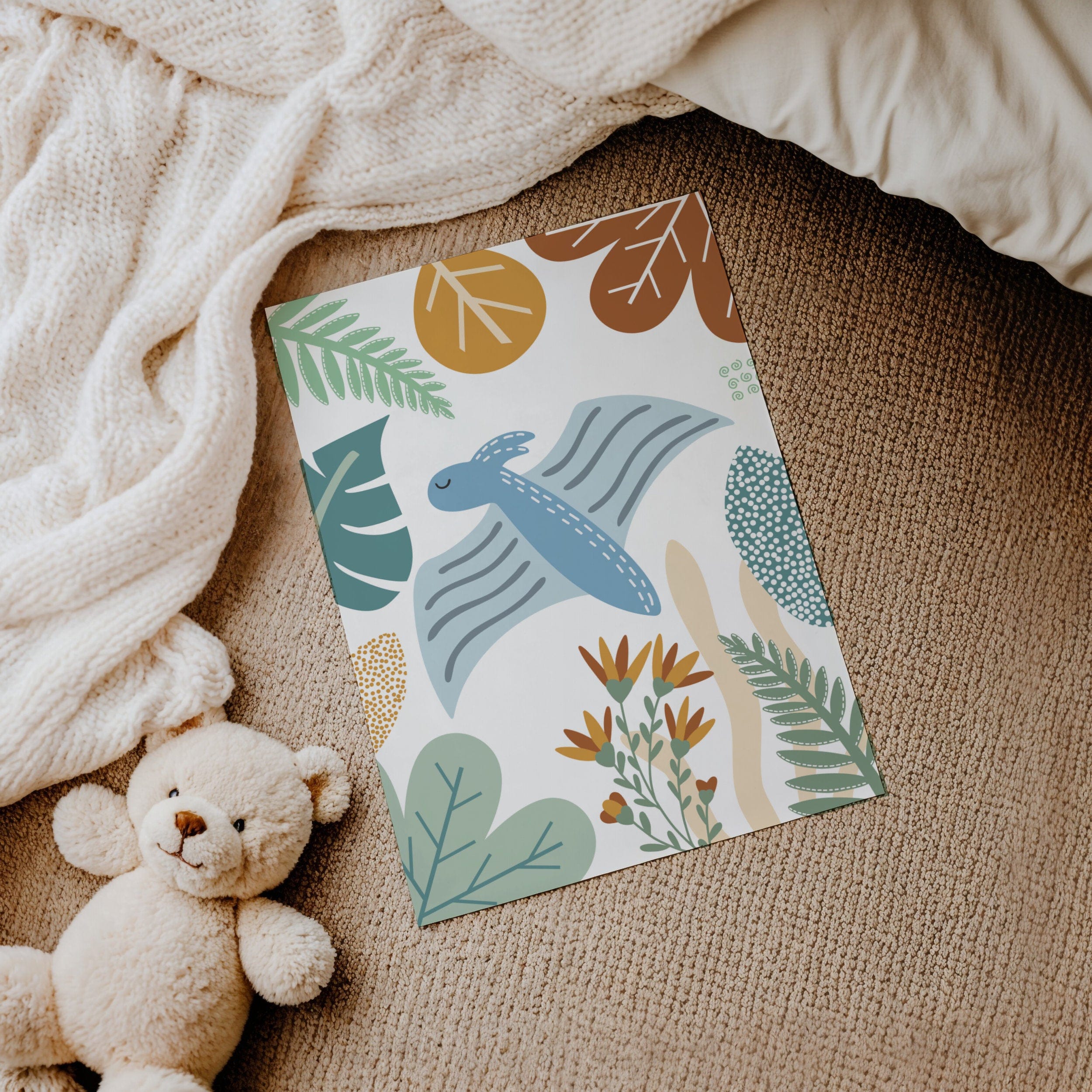 Colorful print with a dinosaur and leaves design on a textured surface with a teddy bear.