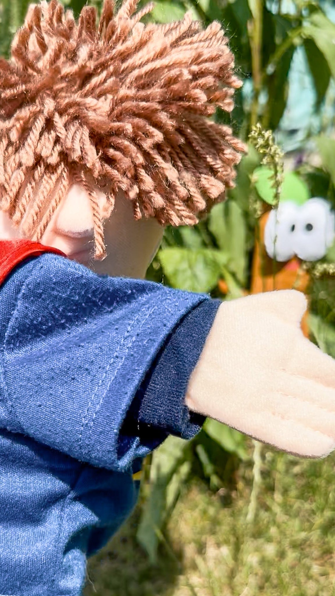 Fred puppet pointing at a bug during a playful garden nature hunt activity