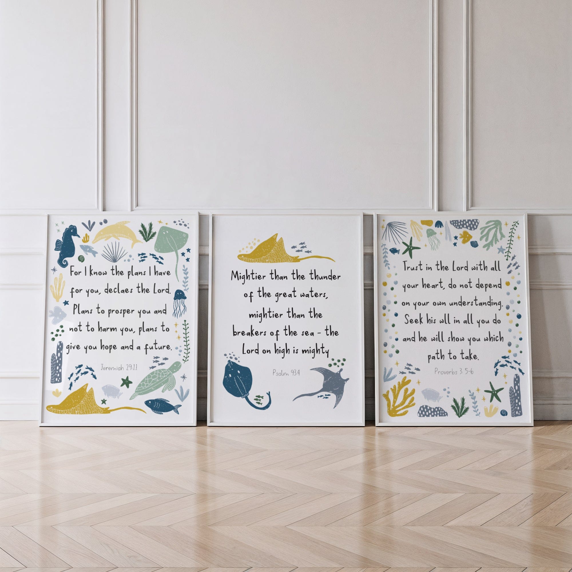 Three framed prints with biblical verses and illustrations on a wooden floor.