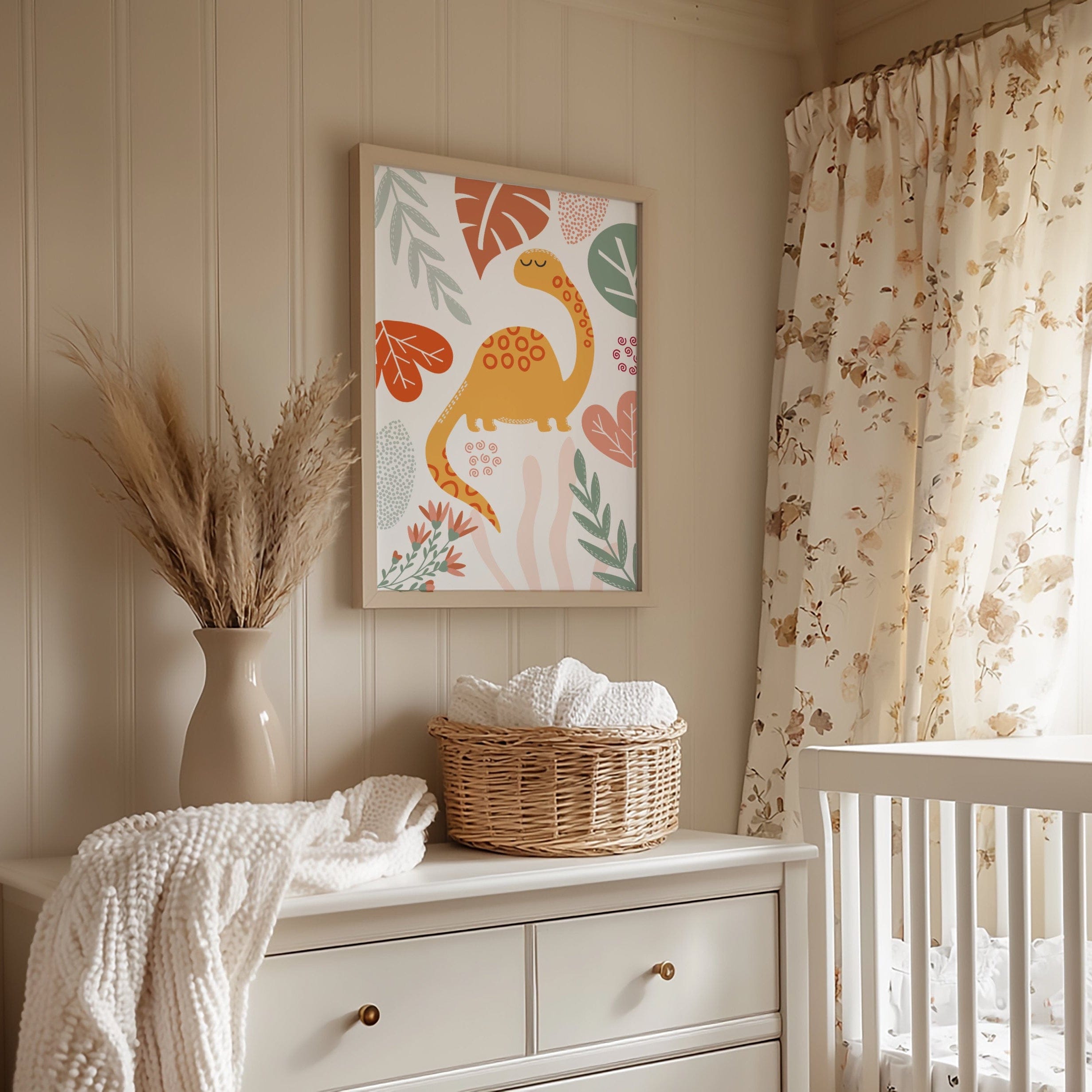 Nursery room with a white dresser, basket, and dinosaur-themed wall art.