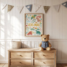 Wooden dresser with teddy bear, basket, and framed dinosaur artwork in a nursery setting.