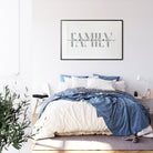 Bedroom with a bed, pillows, and a framed family print on the wall.