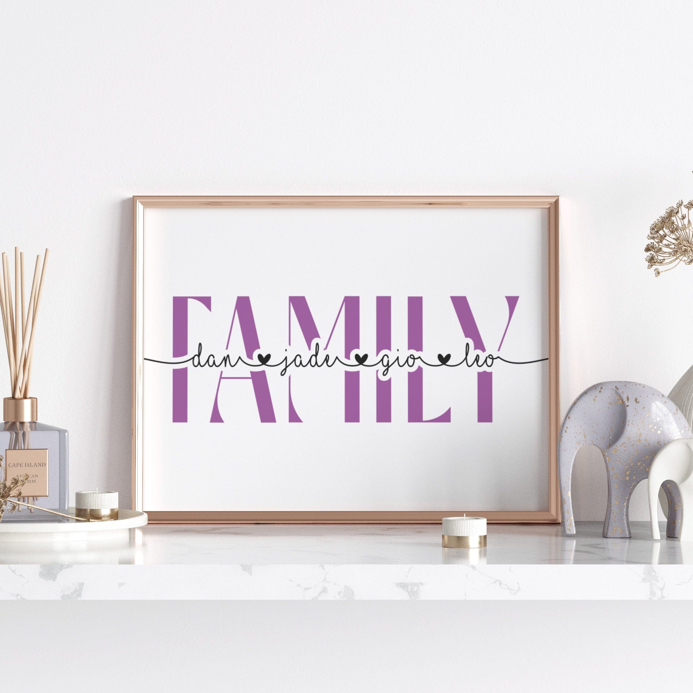 Framed artwork with 'family' text on a white surface with decorative items.