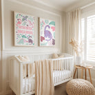 Nursery room with a crib and framed pink dinosaur artwork on the wall.