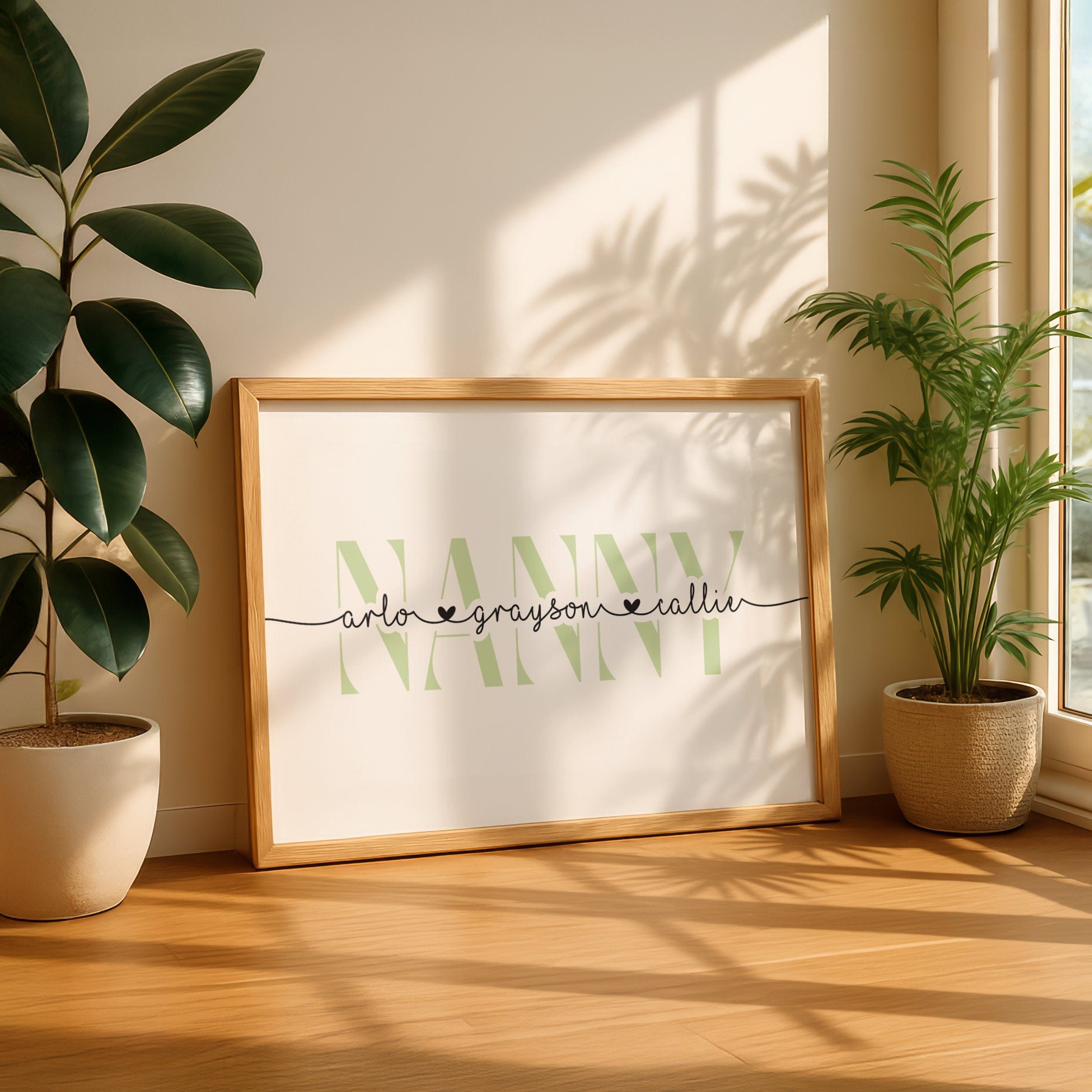 Framed artwork with 'Nanny' and children's names in a home setting with plants.