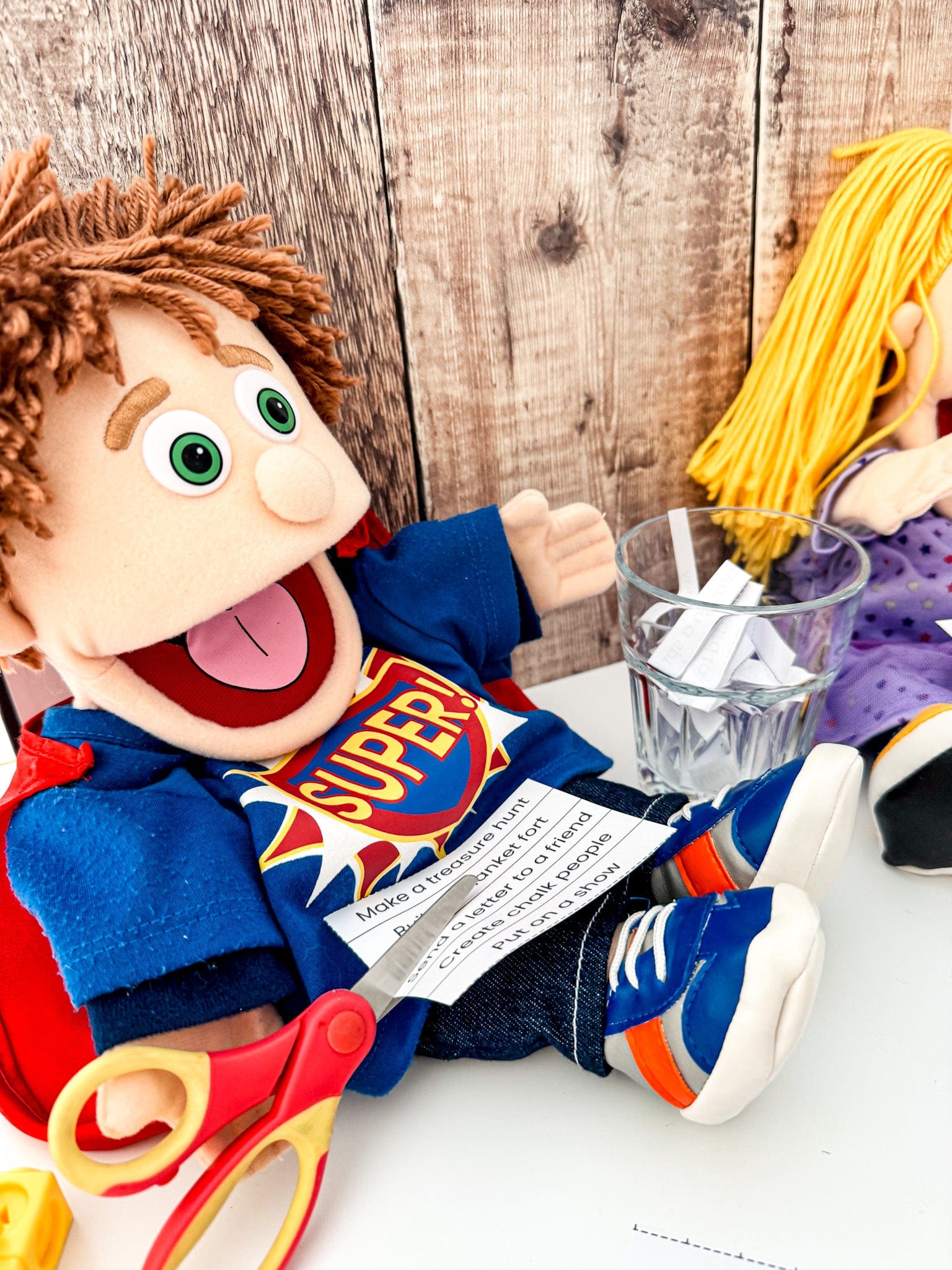 Fred puppet cutting up a prompt slip to put in a glass boredom jar as part of the Summer of Play